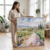 05 - Woman standing in living room with Large Napa Valley Vineyard Watercolor - Square Canvas Print with Natural floater Frame.jpg