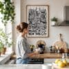 02 - Framed New York City Art - Pencil Style Art Print hanging in Kitchen with woman making coffee - Vertical.jpg