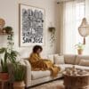 02 - Framed San Jose City Art - Pencil Style Art Print - In Bohi Living Room with Woman reading - Vertical.jpg