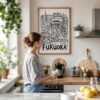 05 - Framed Fukuoka City Art - Pencil Style Art Print hanging in Kitchen with woman making coffee - Vertical.jpg