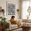 05 - Framed Hong Kong City Art - Pencil Style Art Print - In Bohi Living Room with Woman reading - Vertical.jpg
