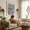 05 - Framed Taipei City Art - Pencil Style Art Print - In Bohi Living Room with Woman reading - Vertical.jpg